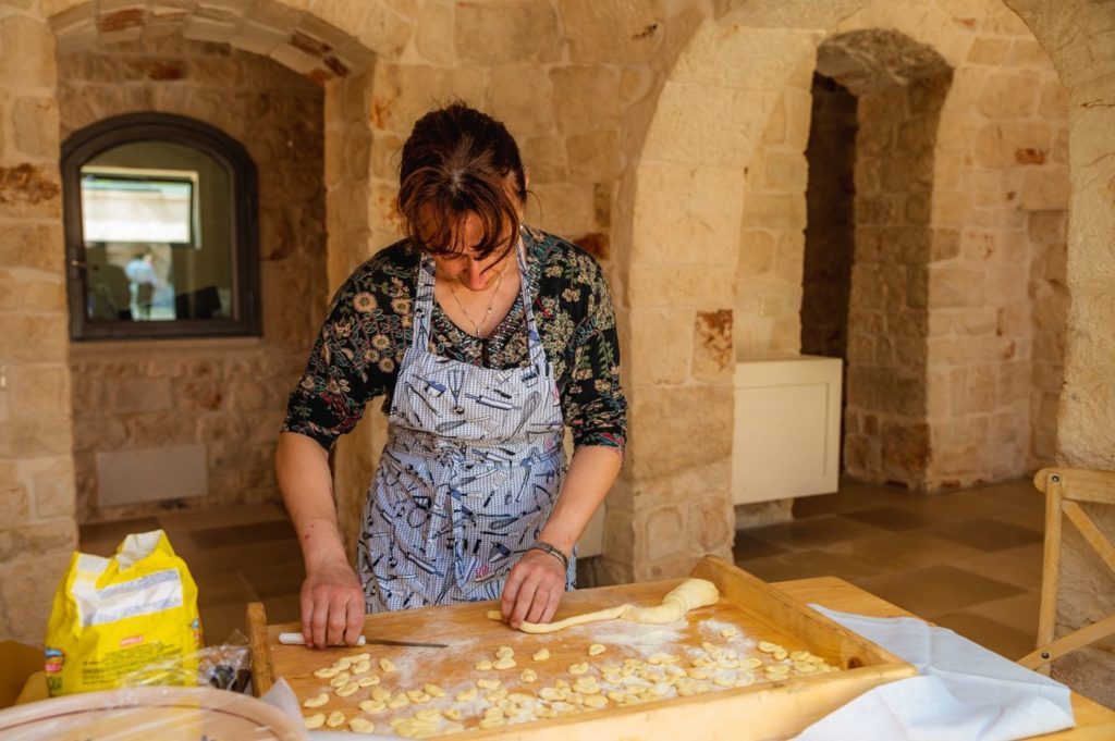 Signora che realizza pasta fresca orecchiette home made 